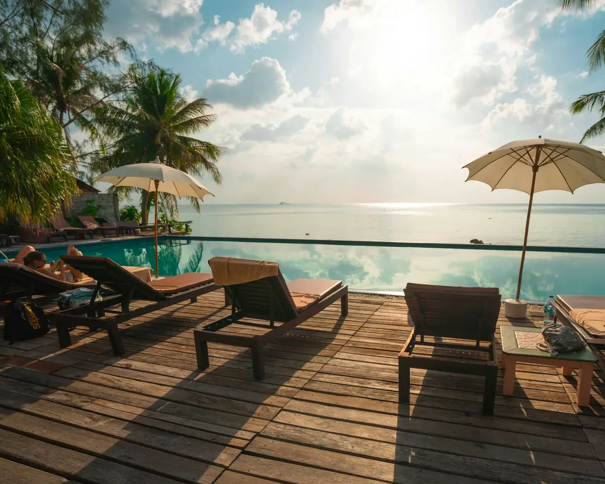 Loungers on a deck beside an infinity pool facing the sea