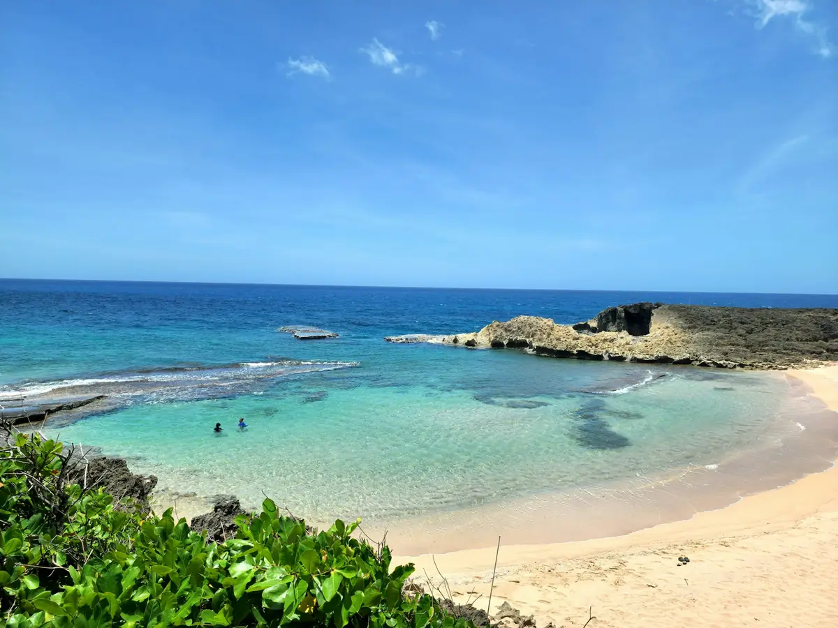 Clear turquoise water over a sandy cove